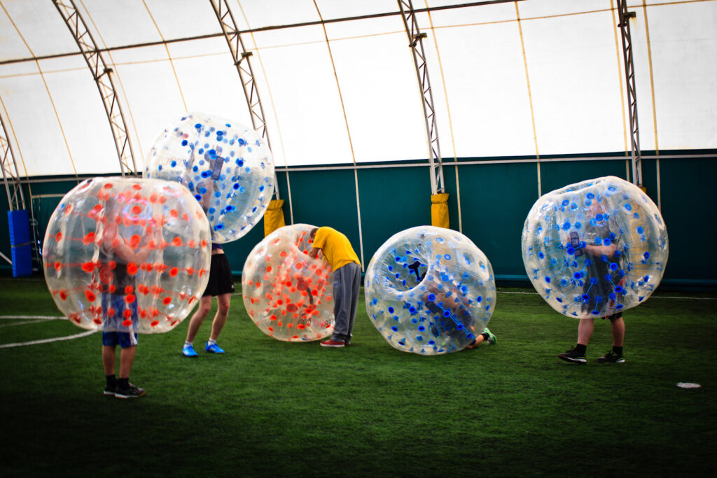 Gra w kulach bumper ball na sztucznej trawie w hali pod balonem